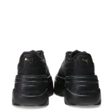 Championes Puma modelo Karmen, de diseño urbano con plataforma elevada. Presentan un exterior sintético en color negro, con cordones al tono y detalles metálicos en los ojales superiores. Su suela robusta de goma proporciona estabilidad y un estilo moderno.