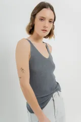 Musculosa gris tejida con hilo brillante, escote en V delantero y trasero.