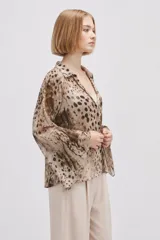 Blusa de poliéster de corte holgado con cuello en V, mangas largas acampanadas y estampado abstracto multicolor en tonos marrones y beige.