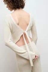 Blusa color crema de punto 100% algodón, con cuello redondo y mangas largas acampanadas.