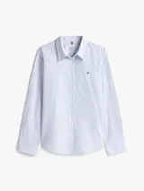 Camisa Tommy Hilfiger a rayas verticales celestes y blancas, de corte regular, manga larga con puños abotonados y cuello inglés.