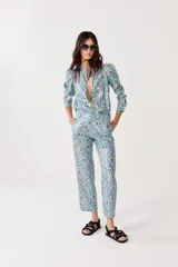 Pantalón de lino metalizado con estampado floral, tiro medio, piernas rectas y bolsillos laterales.