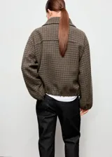 Chaqueta tipo bomber con estampa de pata de gallo en tonos marrones y verdes, cuello camisero, cierre frontal con cremallera y bajo y puños elásticos.