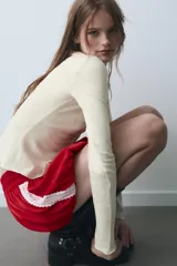 Shorts de tiro medio confeccionados en satén rojo, con diseño tipo globo y cintura elástica ajustable mediante cordones. Presentan detalles de encaje blanco en los laterales.