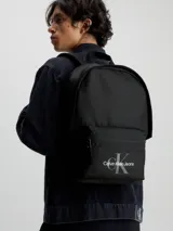 Mochila negra Calvin Klein Jeans con bolsillo frontal y logo estampado en blanco.