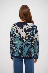 Buzo de tejido de punto con diseño estampado abstracto en tonos azul marino, celeste y amarillo. Presenta cuello redondo, mangas largas y terminaciones en tejido acanalado.