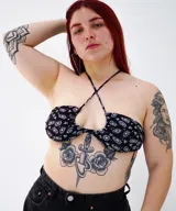 Top de bikini con estampado abstracto en blanco y negro, con tiras finas que se cruzan en el cuello y abertura en el centro del pecho.