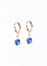 Aros tipo argolla de baño en oro 18k con dije colgante de piedra facetada de color azul intenso.
