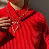 Collar plateado con cadena de eslabones gruesos y dije de corazón con textura irregular.