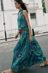 Falda larga de corte evasé con estampado paisley en tonos turquesa, azul y verde, con cintura elástica y cinturón marrón con hebilla dorada incluido.