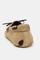 Mocasín de piel con pelo y estampado animal, con detalle de cordones en el empeine y pespuntes decorativos.
