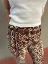 Cinto marrón con textura símil cuero, argollas plateadas y lazos de ajuste.