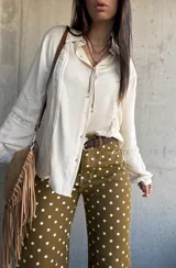 Camisa de manga larga color marfil con detalles de encaje y botones frontales.