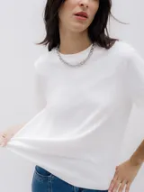 Remera blanca de algodón orgánico con cuello redondo y corte relajado, confeccionada en tejido interlock suave.