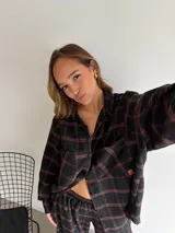 Pantalón de corte recto y holgado, confeccionado en tela de viyela con estampado de cuadros en tonos negro, gris y blanco. Presenta cintura elástica para mayor comodidad.