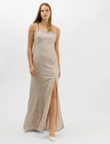Vestido largo de encaje color beige, con escote recto decorado con pedrería y perlas, tirantes anchos y tajo lateral en la falda.