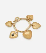 Pulsera de eslabones con baño de oro envejecido, decorada con múltiples colgantes en forma de corazón con detalles grabados y un dije central con piedra oscura.