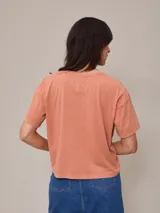 Remera color salmón de corte recto y mangas cortas.