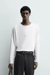 Camiseta de manga larga con cuello redondo y cierre frontal de botonadura tipo henley. Confeccionada en tejido de algodón y seda, con un corte relajado.