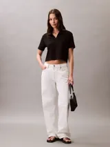 Remera tipo chomba cropped color negro, de algodón acanalado, con cuello polo, cartera abierta y logo bordado en el pecho.