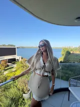 Falda corta color beige, confeccionada en lino, con detalle de puntilla blanca en el ruedo y diseño de corte recto.