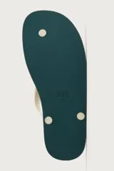 Sandalia de goma color negro, de diseño plano y tiras delgadas en el empeine estilo ojota.
