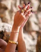 Anillo dorado con diseño irregular que simula un pétalo.