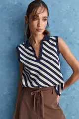 Chaleco tejido de punto con diseño de rayas diagonales en color marrón y beige, cuello polo y escote en V profundo.