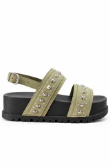 Sandalia plataforma color verde militar con tiras de gamuza decoradas con tachas metálicas plateadas, suela track negra y tira trasera ajustable con hebilla.
