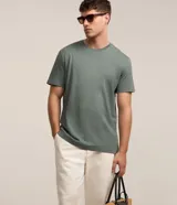 Remera básica de corte comfort y color verde, confeccionada en algodón peruano, con mangas cortas y cuello redondo.