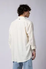 Camisa de manga larga confeccionada en lino, color verde oliva, con cuello clásico y cierre frontal de botones.