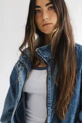 Campera de denim azul con diseño oversize, cuello alto con cierre y bolsillos frontales.