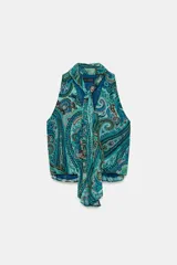 Top sin mangas de cuello alto con lazo ajustable, escote en V y diseño cruzado en el delantero. Presenta un estampado paisley en tonos verdes, azules y rosados, con bajo elástico y forro interior.