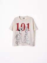 Remera de algodón color off-white con estampa frontal de los personajes de 101 Dálmatas y el número 101 en color rojo.