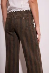 Pantalón de jean de tiro medio, corte wide leg acampanado, con estampado de rayas verticales en tonos marrón oscuro y negro.