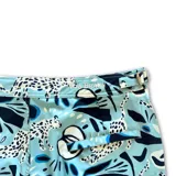 Short de baño con estampado abstracto en tonos celestes y azules. Cuenta con pretina fija, hebillas metálicas laterales para ajuste, cierre frontal con botón a presión y tres bolsillos.