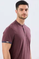 Remera estilo polo con cuello mao y manga corta, de color bordó con detalles en azul en los bordes de las mangas y cuello. Cuenta con cierre frontal parcial de tres botones y pequeño logo bordado en el pecho.