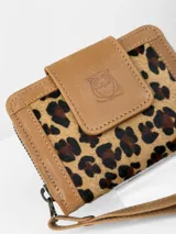 Mini billetera Chabas confeccionada en cuero con detalle frontal en pelo con estampado animal print. Cuenta con solapa de cierre con logo de búho grabado y correa de muñeca extraíble.