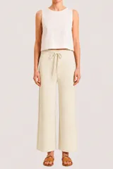 Pantalón de corte recto y tiro medio, confeccionado en tejido de punto color crema. Presenta cintura elástica con cordón ajustable y diseño holgado.