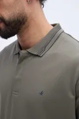 Chomba de piqué en color negro, de manga corta, con cuello y puños tejidos con líneas a contraste. Presenta cierre frontal parcial con botones y pequeño logo bordado en el pecho.