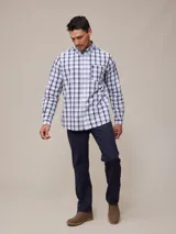 Camisa de manga larga para hombre, confeccionada en algodón con efecto peach (textura suave). Presenta un estampado de cuadros vichy en tonos azul marino y blanco, cuello con botones y un bolsillo de parche en el pecho izquierdo.