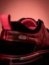 Championes urbanos de edición limitada inspirados en Darth Vader, confeccionados en cuero negro con detalles en rojo. Presentan el logo de Star Wars en la lengüeta y un diseño minimalista con cordones.