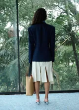 Blazer de doble botonadura color azul marino con estampado de raya diplomática, cuello en pico con solapa de muesca, bolsillos con solapa y diseño recto.