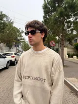 Sweater de tejido acanalado en color beige, con corte semi oversize, cuello redondo y logo bordado en el pecho.