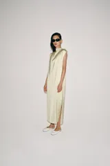 Vestido midi de Zara Woman Collection confeccionado en hilatura de viscosa con tejido satinado, de color beige. Presenta cuello subido, diseño sin mangas (manga sisa), bajo recto con aberturas laterales y cierre en la espalda con alamares.