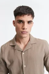 Camisa de manga corta color crema con textura, cuello clásico y calce regular.