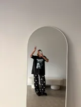 Remeron negro de corte oversize con estampa frontal de gatos. Confeccionado en algodón, presenta cuello redondo y mangas cortas.