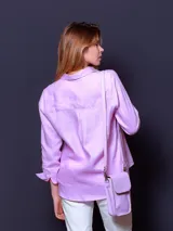 Camisa de lino color celeste, de manga larga, con cierre frontal de botones y cuello camisero.