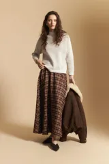 Falda larga de corte amplio y fluido con estampado de cuadros en tonos tierra. Presenta un diseño de tiro medio que aporta elegancia y comodidad.