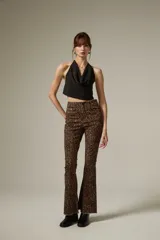 Pantalon de jean con corte flare y tiro alto, estampado con diseño animal print de leopardo en tonos marrones. Cuenta con bolsillos funcionales y ruedo desflecado.